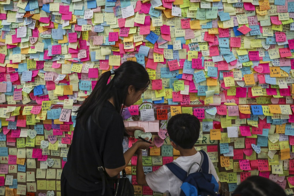 A mother and her son post a message on the Lennon Wall in Tsuen Wan. Photo: Sam Tsang