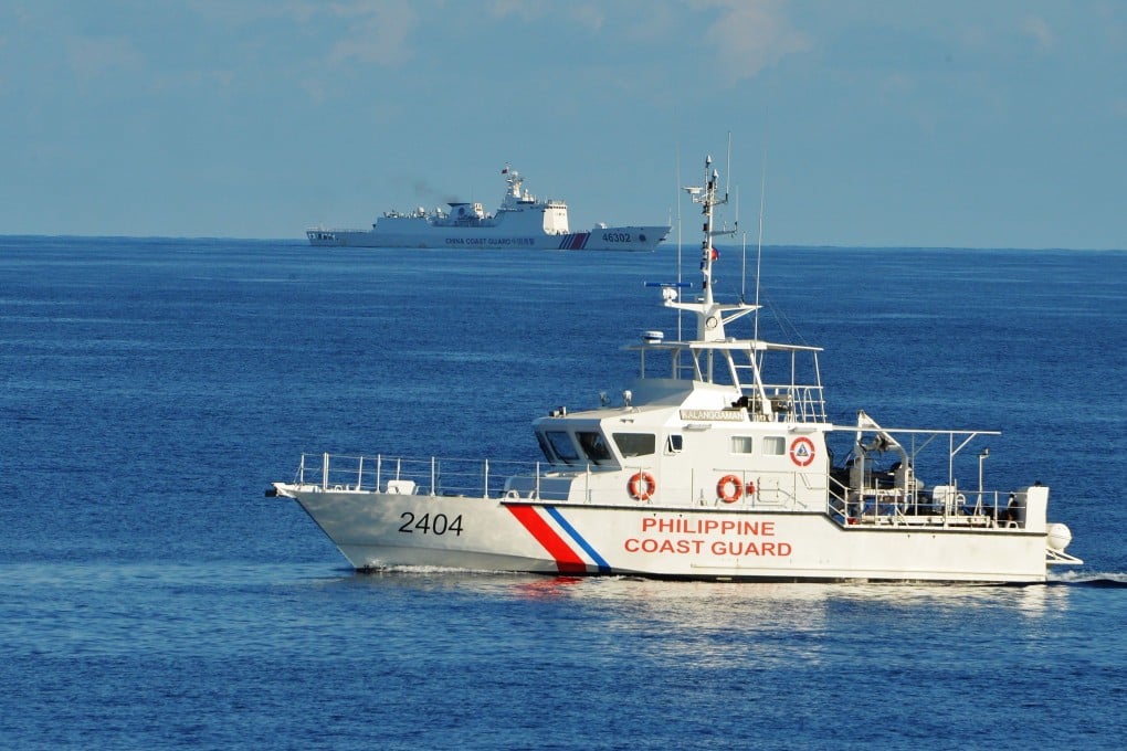 A Philippine coastguard ship sails past a Chinese coastguard vessel during a Philippine-US rescue exercise near the Scarborough Shoal in the South China Sea. Photo: AFP