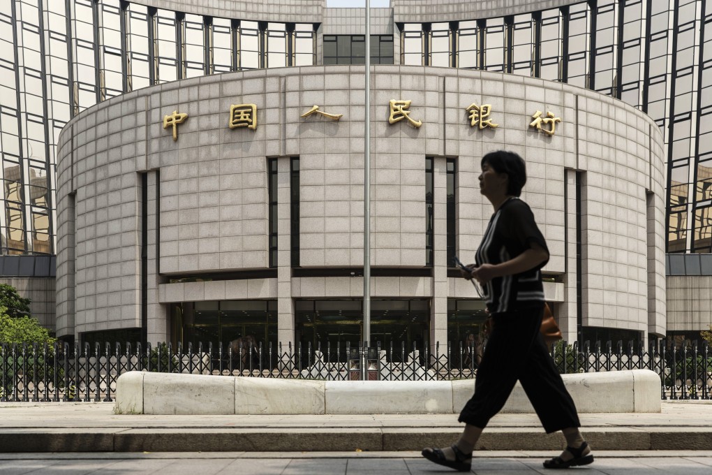A pedestrian walking past the People's Bank of China headquarters in Beijing, China recently. A committee of the central bank said on Saturday that China would remove shareholding limits on foreign ownership of securities, insurance and fund management firms in 2020, one year earlier than originally planned. Photo: Bloomberg