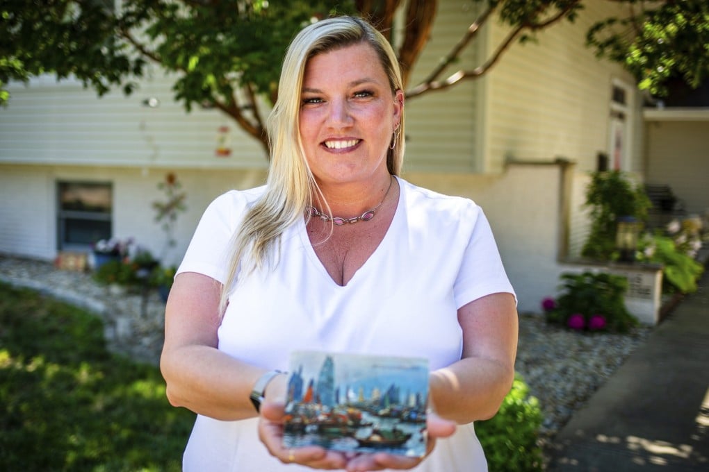Kim Draper with the postcard at her home in Springfield on July 8. The postcard was postmarked and sent from Hong Kong exactly 26 years ago on July 8, 1993, to a previous family that lived at her address. Photo: AP