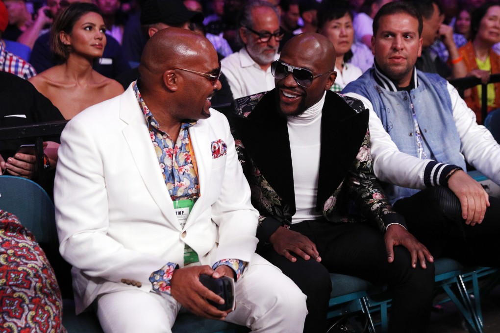 Floyd Mayweather Jnr (centre) speaks to American businessman, Leonard Ellerbe, at the Manny Pacquiao-Keith Thurman fight in Las Vegas over the weekend. Photo: EPA