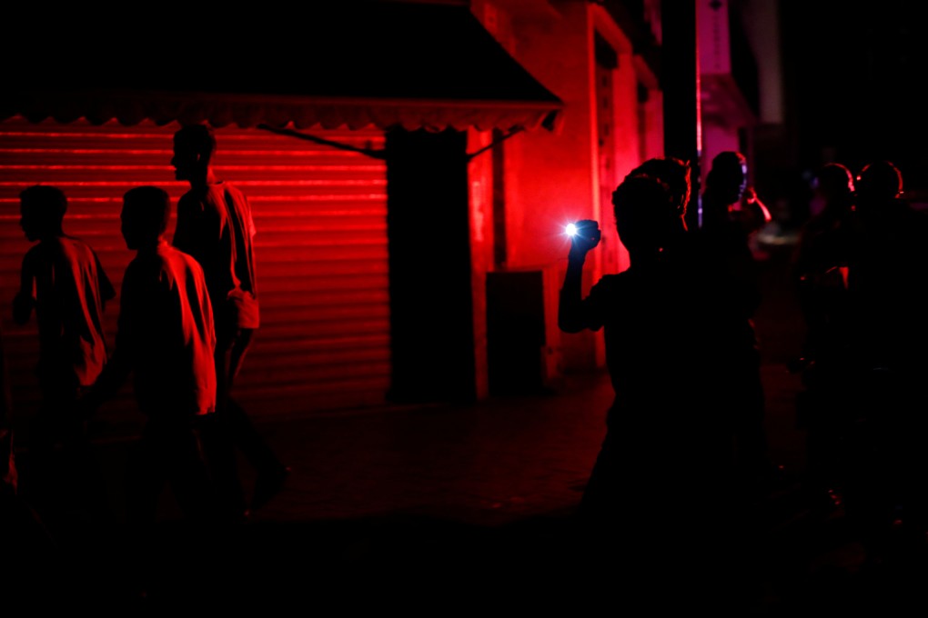 People walk home in the dark in Caracas after street lights stopped working. Photo: Reuters