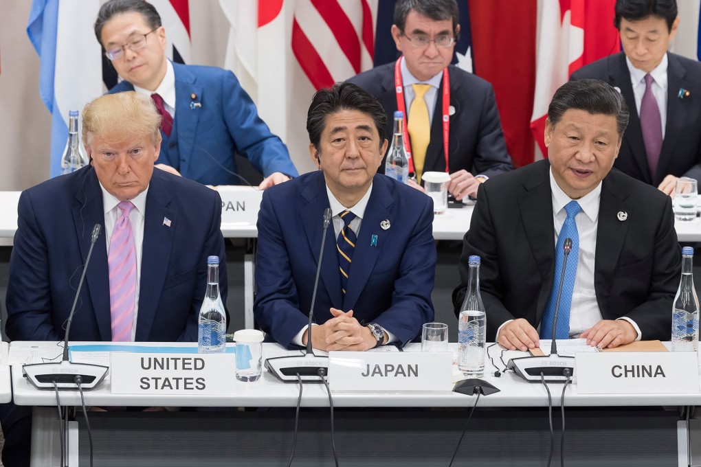 US President Donald Trump (from left) sits with Japanese Prime Minister Shinzo Abe and Chinese President Xi Jinping as they attend a meeting on the digital economy at the G20 Summit in Osaka on June 28. Photo: TNS