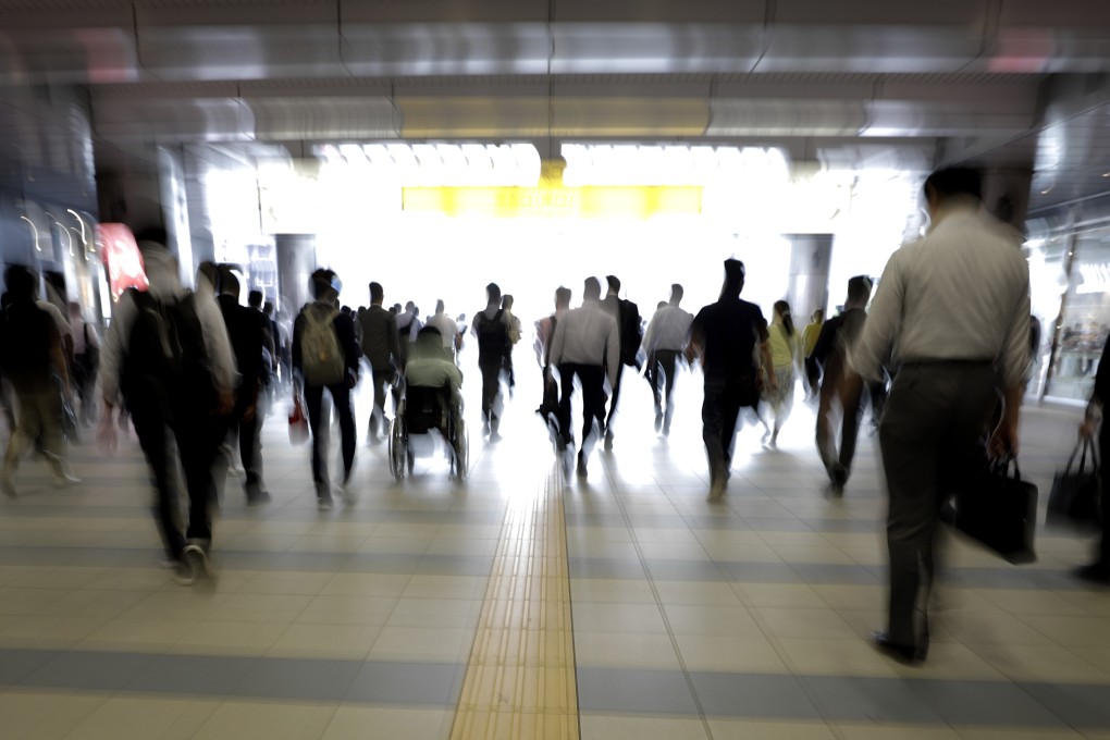 Morning commuters exit a railway station in Tokyo. Photo: Bloomberg