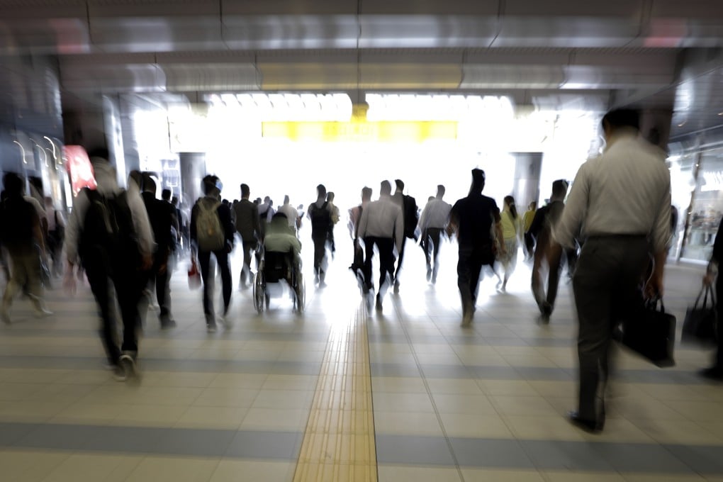 Morning commuters exit a railway station in Tokyo. Photo: Bloomberg