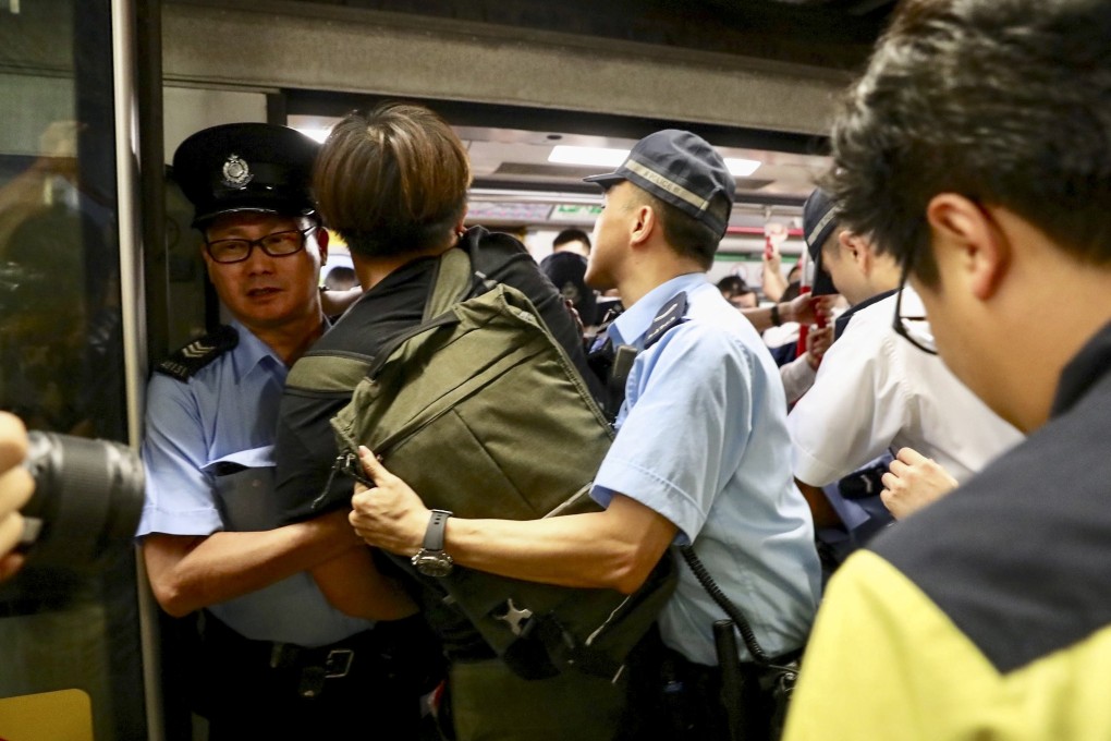 Police restrain protesters trying to prevent Chai Wan-bound trains from leaving the Admiralty MTR station by obstructing train doors during the morning rush hour of July 24. The protesters were taking part in a non-cooperation campaign against MTR Corp to seek accountability over violent attacks on passengers at Yuen Long station on July 21. Photo: Nora Tam