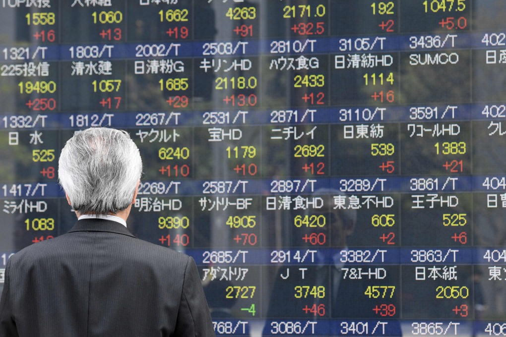 A businessman looks at an electronic share indicator at the window of a securities company in Tokyo on April 24, 2017. Photo: AFP
