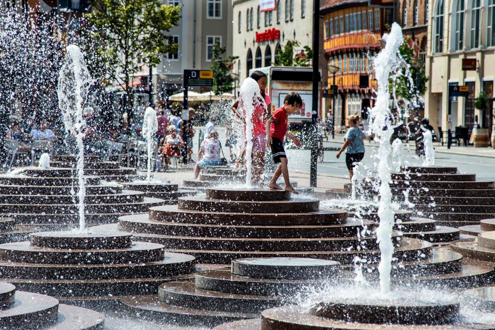 People cool off in the fountains at Toldbod Plads in Aalborg, Denmark. Photo: AFP