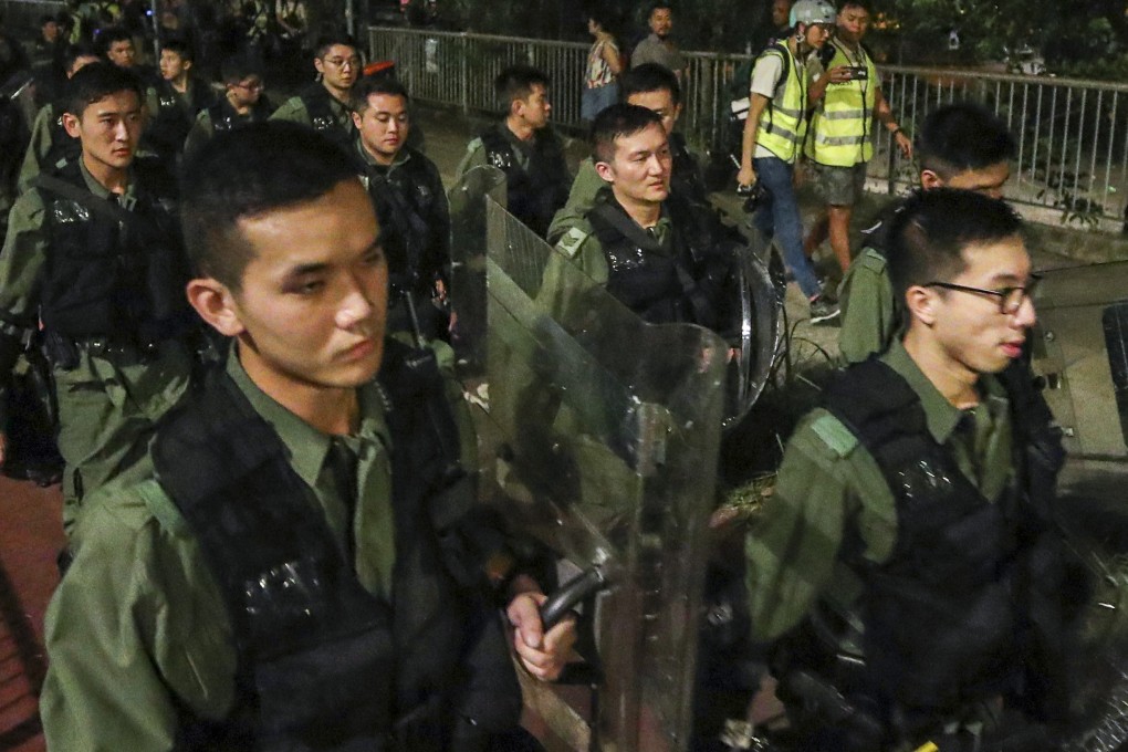 Police patrol the streets of Yuen Long on Sunday after a mob of men in white T-shirts attacked black-clad protesters and passengers. Photo: Winson Wong