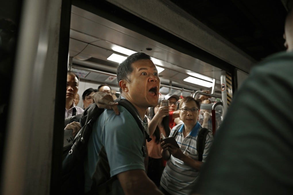 A passenger reacts as protesters block train doors and disrupt train service in Hong Kong during the morning rush hour on July 24. Photo: AP