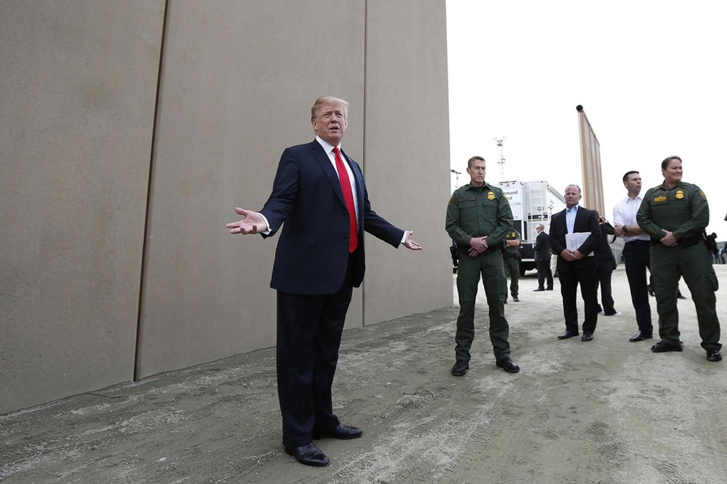 President Donald Trump looks at border wall prototypes in California last March. Photo: TNS