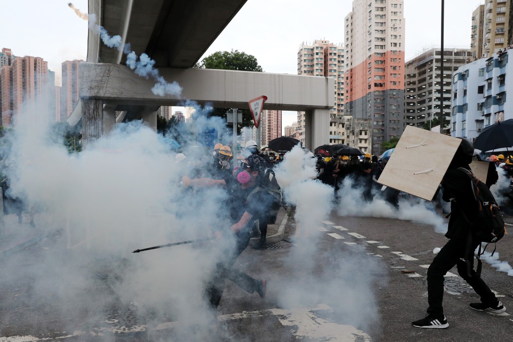 A protester throws a tear gas cannister back towards police during clashes near Kwan Lok Sun village, in Yuen Long. Photo: Sam Tsang