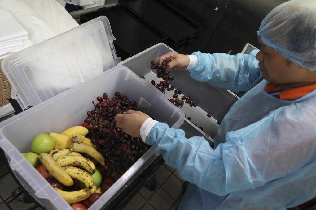 A staff member at a luxury hotel in Hong Kong packs excess food for collection by charity Food Link, which distributes food to needy Hongkongers. It is one way hotels are reducing food waste as part of a sustainability drive. Photo: Nora Tam