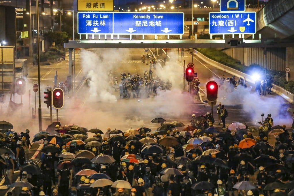 Riot police fire tear gas at protesters as they head towards the central government’s liaison office in Sai Ying Pun on Sunday. Photo: Sam Tsang