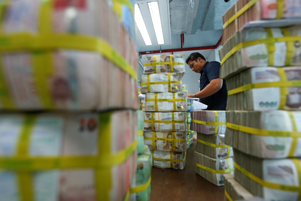 A bank employee sorts Thai baht notes in Bangkok. Photo: Reuters
