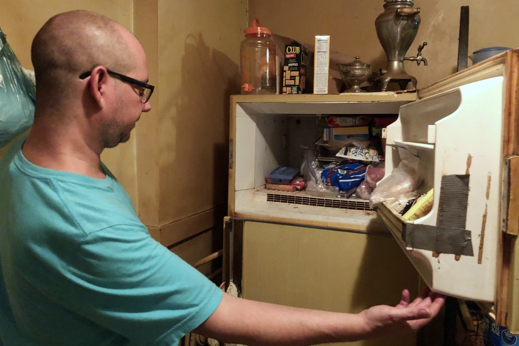 Adam Smith peers into his mother's freezer in St Louis on Monday. He had found the remains of an infant inside a box she had kept for years. Photo: St Louis Post-Dispatch via AP