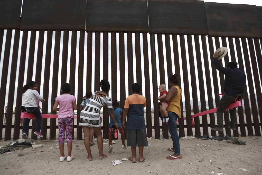 Children and a man in Ciudad Juarez, Mexico play on a seesaw installed at the border fence between Mexico and the US on Sunday. Photo: AP