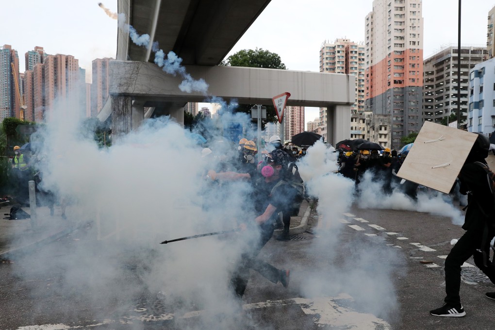 A protester throws a tear-gas canister back at police during clashes in Yuen Long. Photo: Sam Tsang