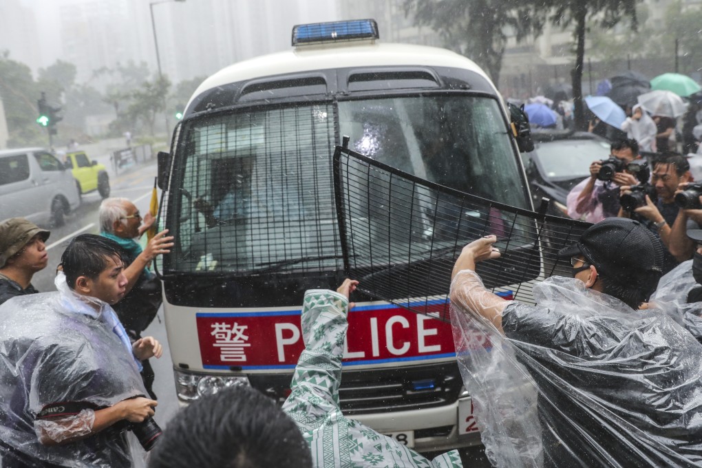 Protesters attack a police van outside the Eastern Court in Sai Wan Ho, where 44 people charged for rioting appeared before magistrates on Wednesday. Photo: Sam Tsang