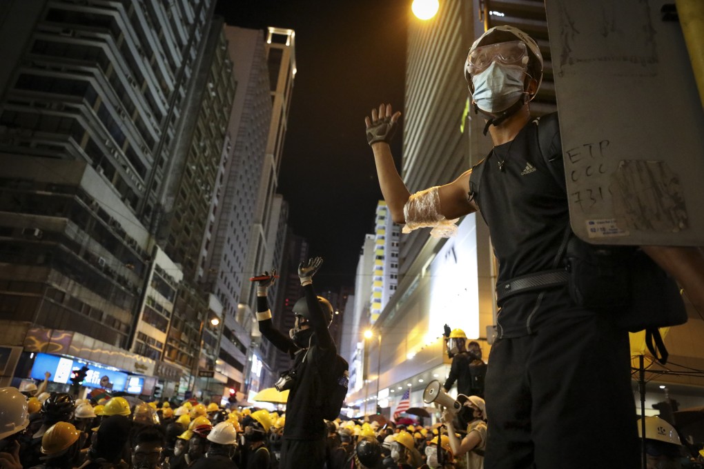 Young protesters signal to one another during clashes with riot police on the night of July 28. Photo: James Wendlinger