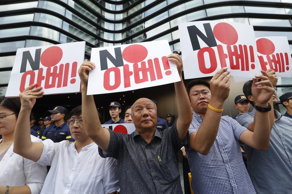 South Korean protesters hold placards during a rally outside the Japanese embassy in Seoul on Friday. Japan will remove South Korea from its list of trusted trade partners. Photo: AP