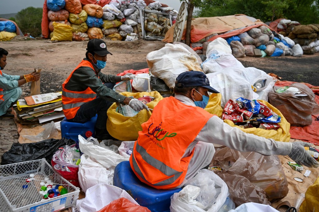 Municipal workers sort out recycling items in Islamabad. Photo: AFP