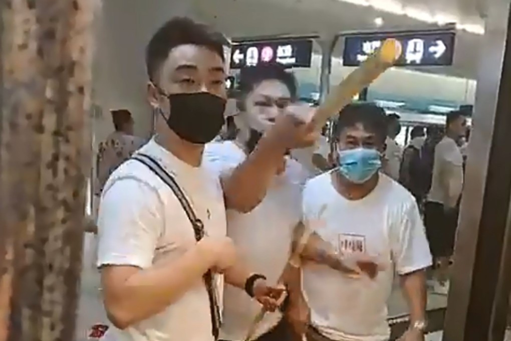 Men dressed in white T-shirts threaten protesters and commuters at Yuen Long MTR station on July 21. Picture: AFP