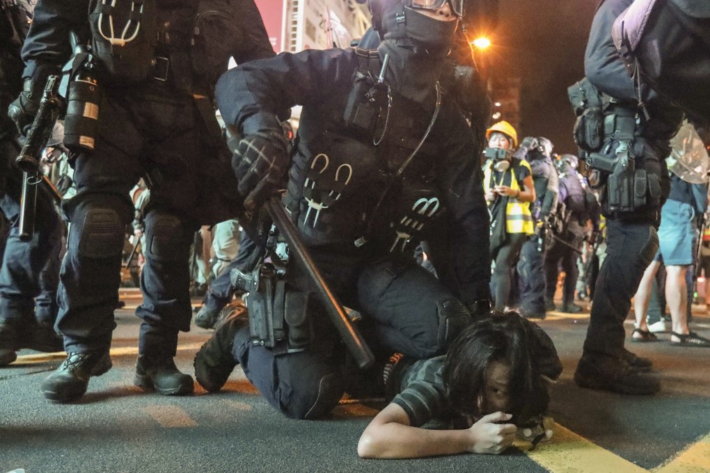 A riot police officer pins a protester to the ground during unrest in Mong Kok. Photo: Felix Wong