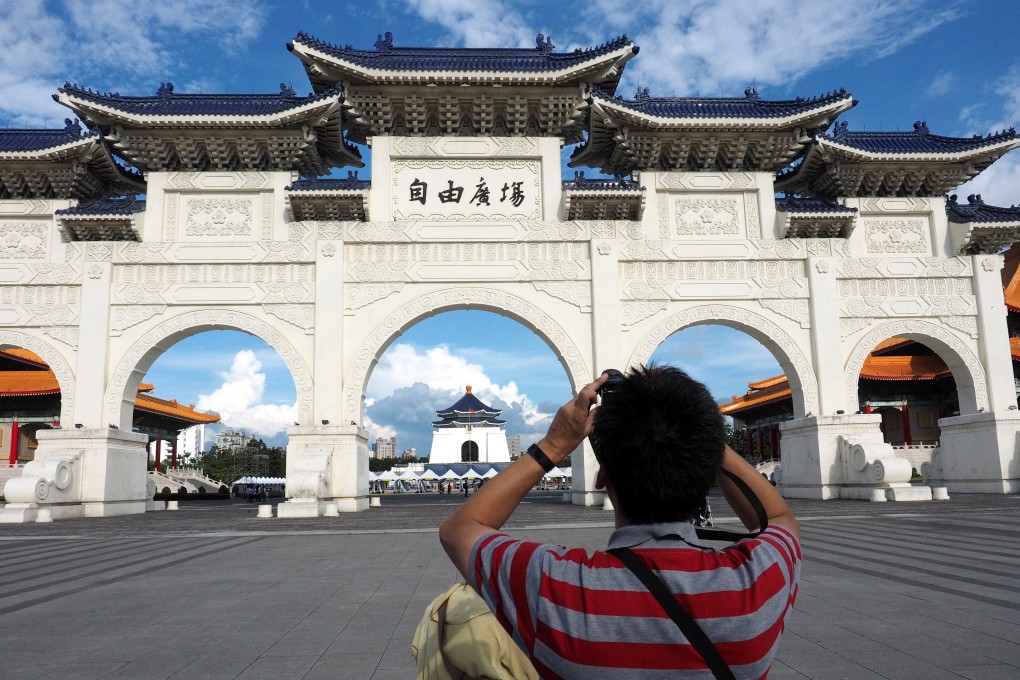 A visitor takes a photo at Liberty Square in Taipei. Beijing has barred mainlanders from travelling to the self-ruled island as individual tourists. Photo: EPA-EFE