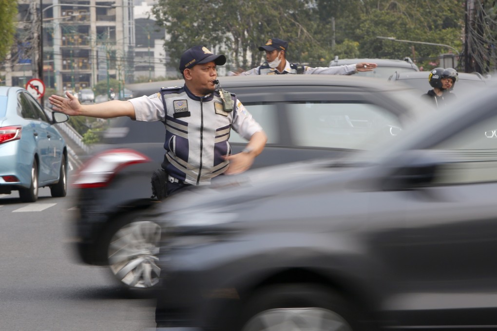 A police officer directs traffic in Jakarta on Sunday after a power blackout. Photo: EPA
