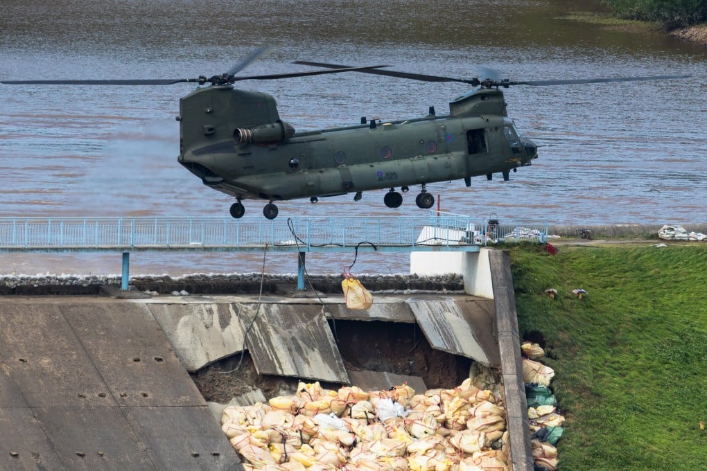 A helicopter drops sandbags onto the damaged dam at Toddbrook Reservoir in Britain. Photo: Photo: EPA