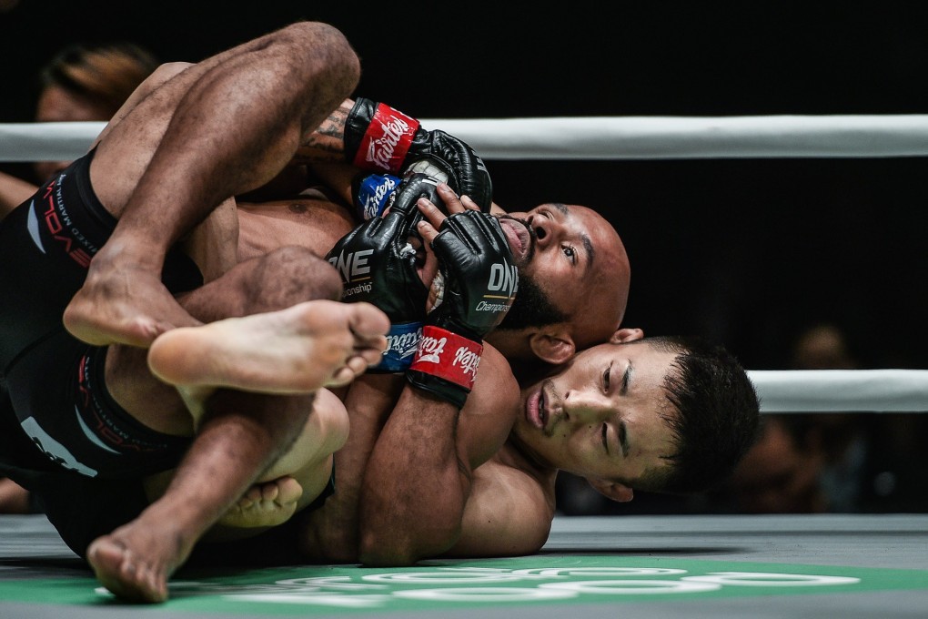 Yuya Wakamatsu takes Demetrious Johnson’s back. Photos: One Championship