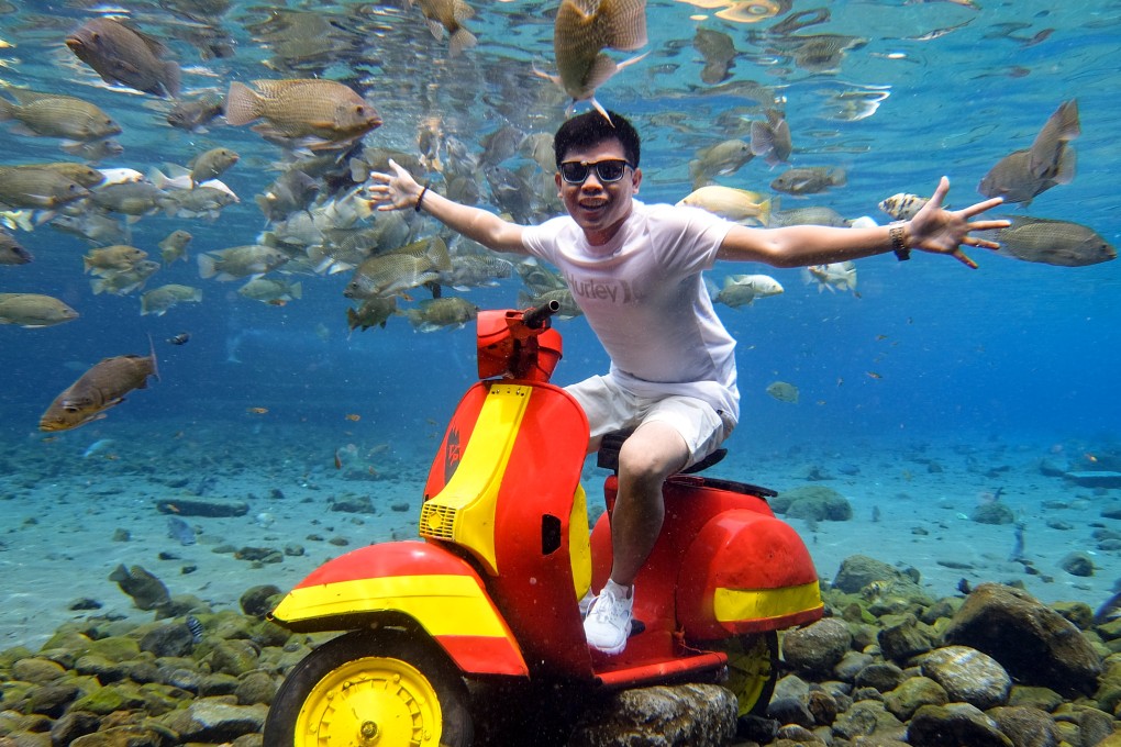 A strategically placed motorcycle is perfect for underwater poses at Umbul Ponggok, Indonesia. Photo: James Wendlinger