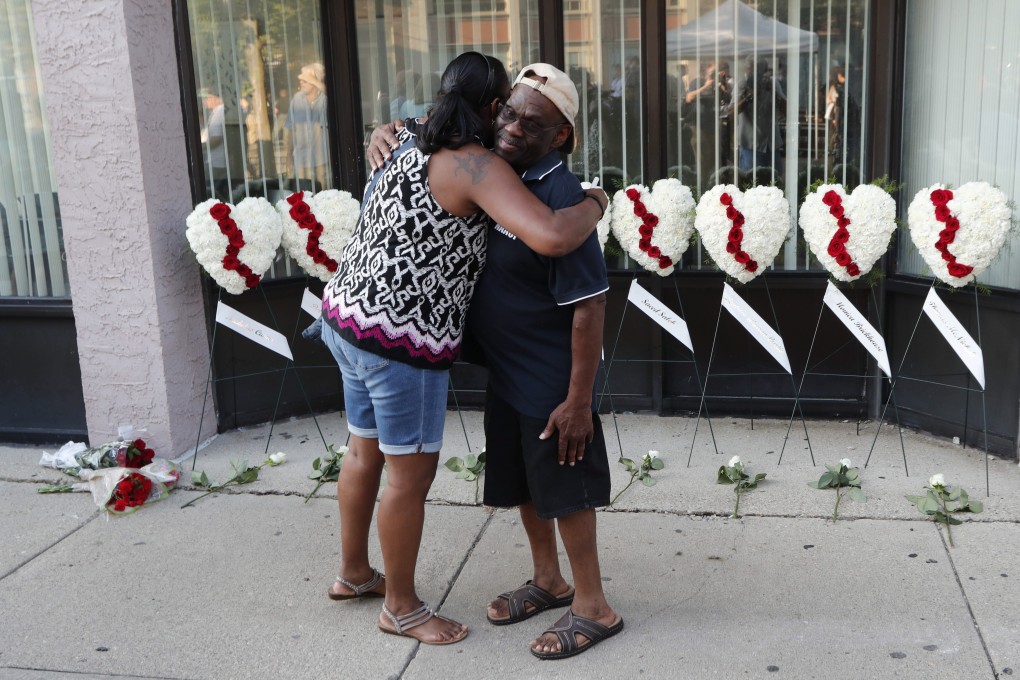 Mourners in front of wreaths displayed for the nine victims of a shooting in Dayton, Ohio. Photo: EPA