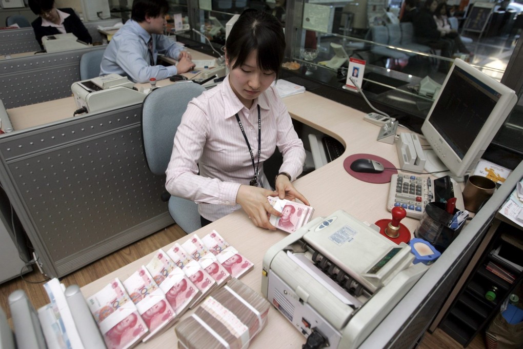 A bank teller counts Chinese 100 yuan notes at a branch of the China Merchants Bank in Beijing on Friday 15 December 2006. Photo: EPA