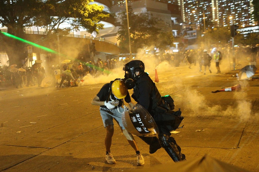 A laser beam is flashed at a police officer trying to grab a protester in Wong Tai Sin on August 5. Photo: EPA-EFE