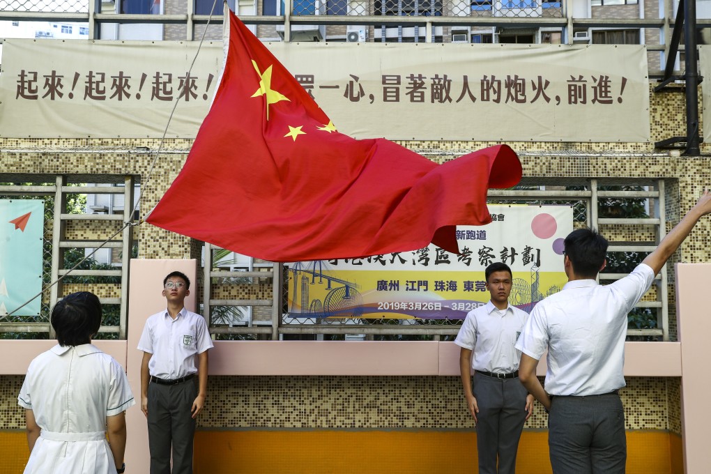 Staff and students from Pui Kiu Middle School in North Point hold flag-raising ceremony on campus on Monday. Photo: Nora Tam
