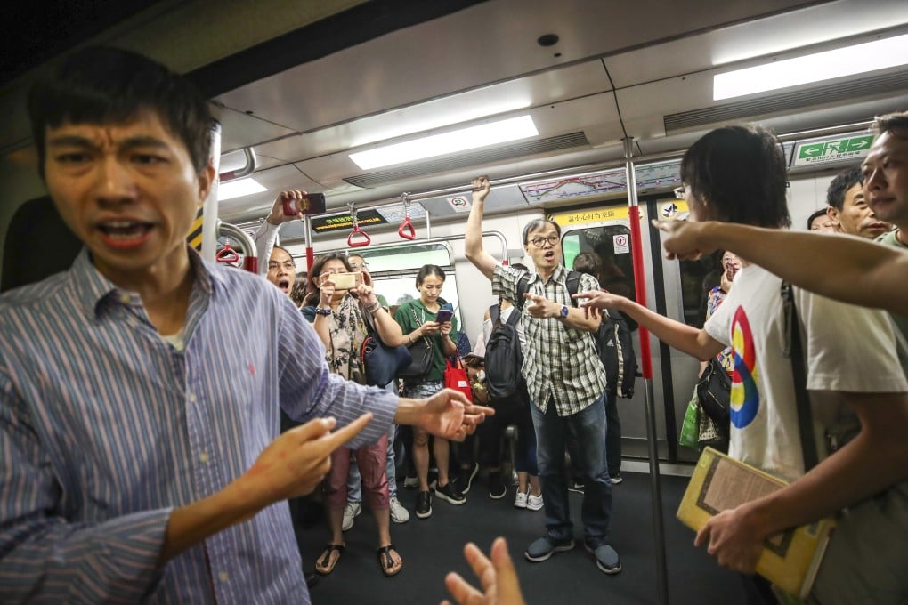 Commuters clash with anti-government protesters who try and stop an MTR train from leaving Fortress Hill station on Monday morning, but services are running smoothly on Tuesday morning. Photo: Winson Wong