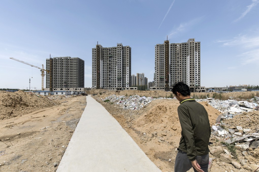 A worker walks towards residential buildings under construction in Qingdao, China, on May 8, 2018. Upgraded property curbs have hit sales in the northern mainland city. Photo: Bloomberg