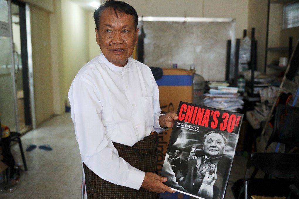 Monywa Aung Shin, editor-in-chief of D. Wave Journal, the NLD’s magazine, shows one of the books he got during his trip to China. Photo: Reuters
