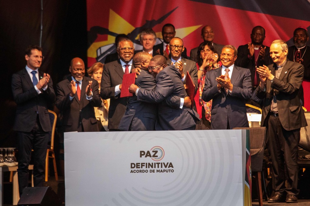 Mozambique's President Filipe Nyusi (centre left) and Renamo leader Ossufo Momade (centre right) embrace after signing a ceasefire agreement in Maputo, Mozambique, on Tuesday. Photo: AFP