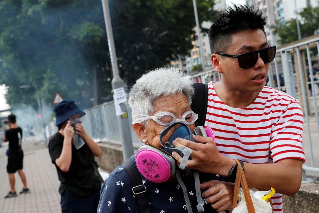 An elderly woman is helped by a demonstrator after police fire tear gas during a protest in Tin Shui Wai on August 5. Photo: Reuters