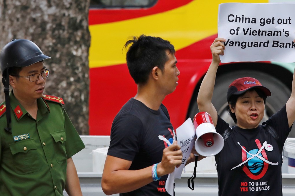 A Vietnamese policeman approaches anti-China protesters demonstrating against Beijing’s actions in the Vanguard Bank stand-off. Photo: Reuters