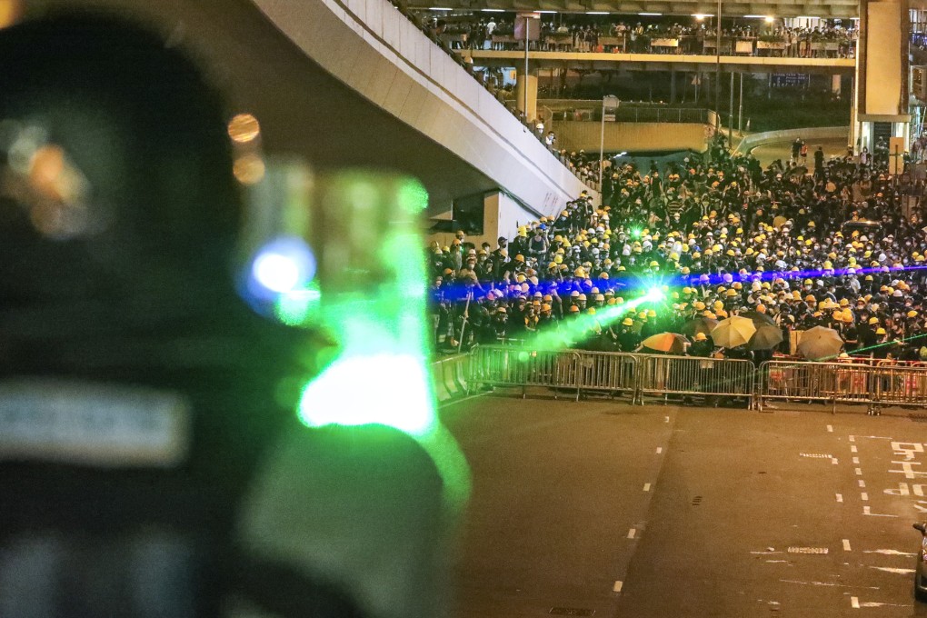 Anti-government protesters shine lasers at riot police in Central. Photo: Felix Wong