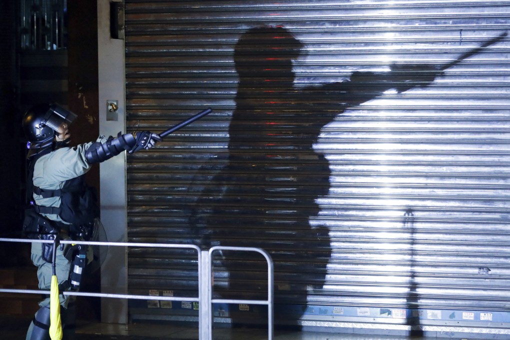 A riot police officer gestures as the police disperses residents and protesters in Sham Shui Po on August 7. Photo: AP in Hong Kong, Wednesday, Aug. 7, 2019. Protesters surrounded a Hong Kong police station to demand the release of a university student arrested for apparently buying laser pointers, sparking the latest confrontation in the Chinese city. (AP Photo/Vincent Thian)
