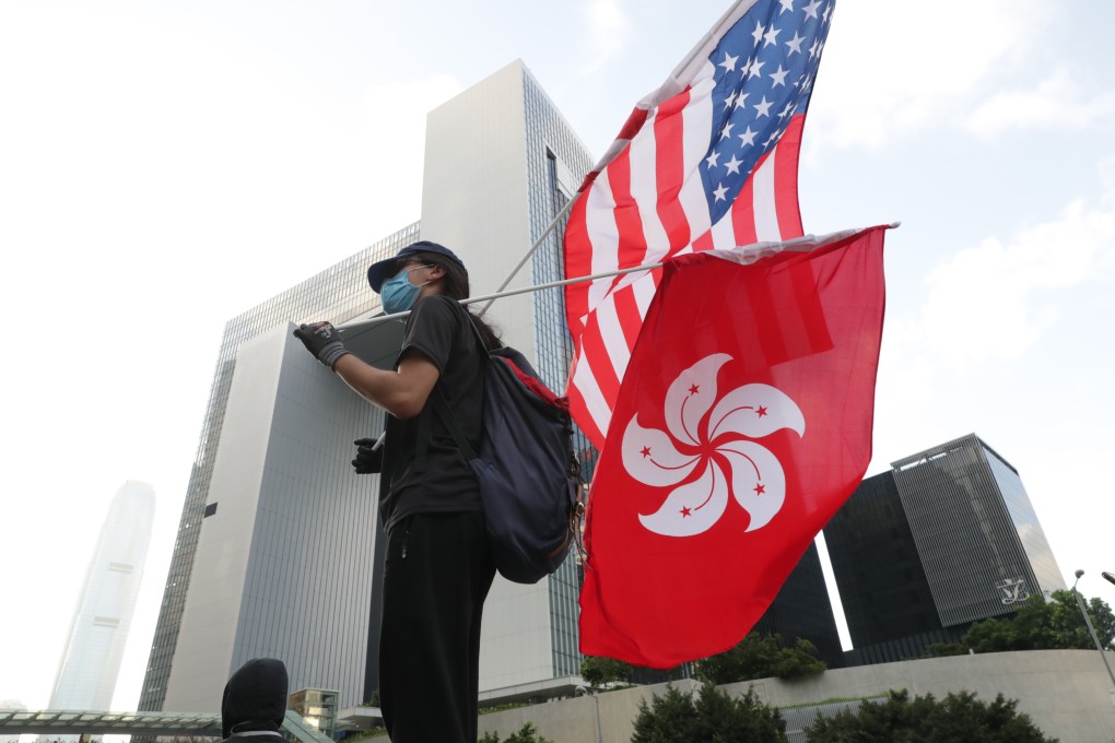 A protester holds a US flag alongside the Hong Kong flag during a march in the city on July 21, 2019. Photo: Edmond So