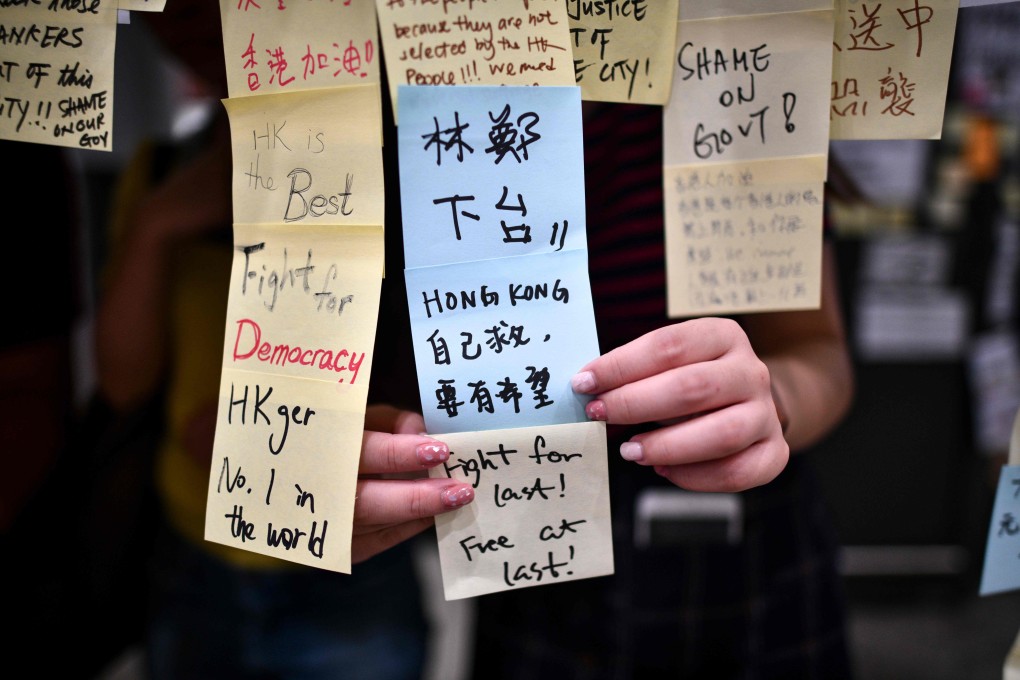 A protester adds notes to a “Lennon Wall” at Hong Kong International Airport on July 26, during one of a series of demonstrations since early June sparked by opposition to a proposed extradition law. Photo: AFP