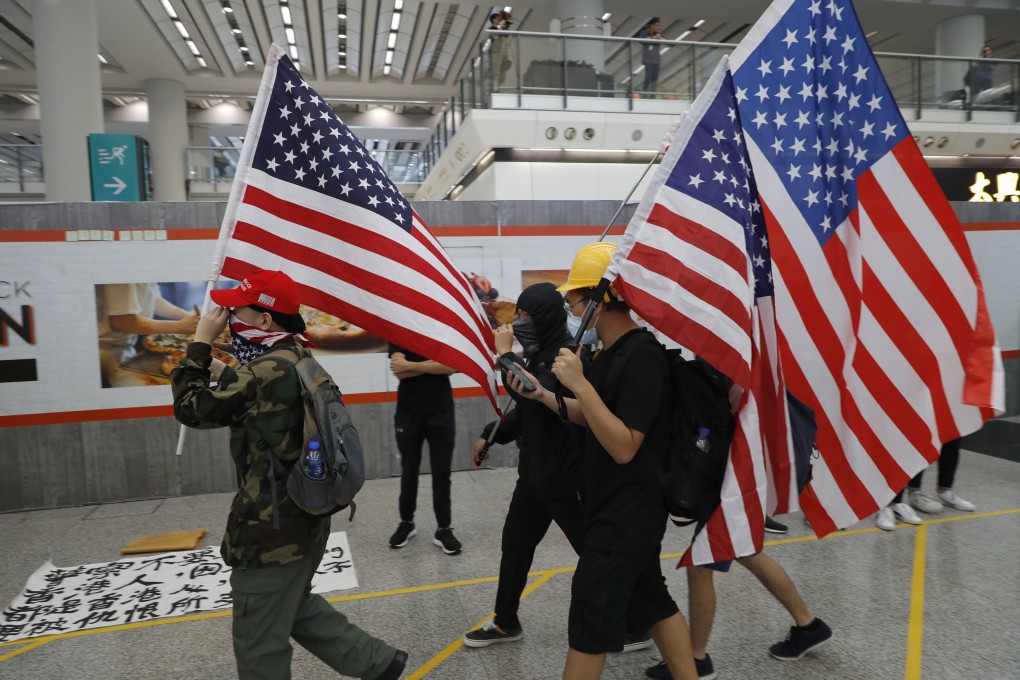 Pro-democracy demonstrators carry US flags during a protest at the Hong Kong airport on Friday. Photo: AP