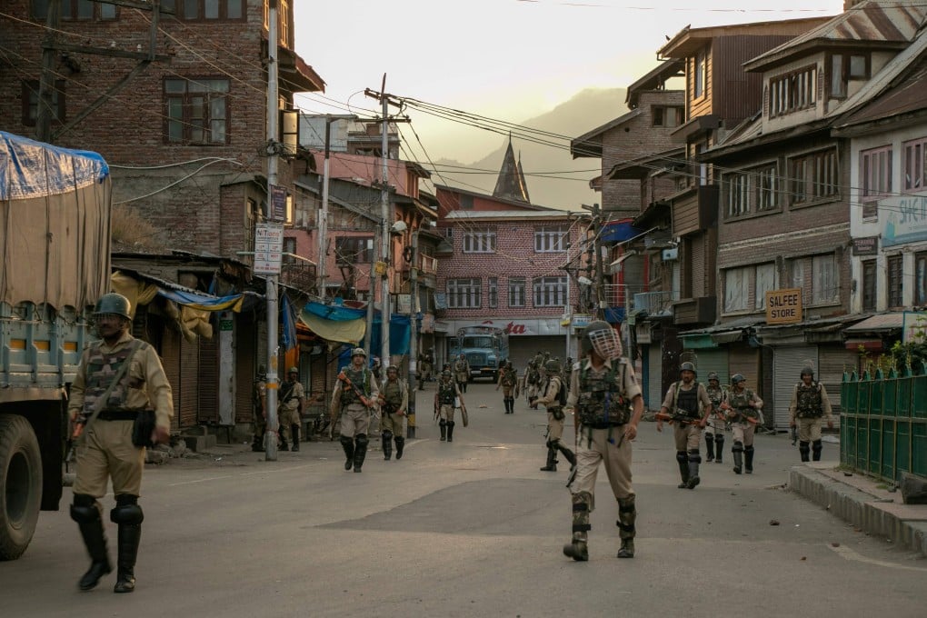 Indian security personnel walk on a street in Srinagar as restrictions on movement and a telecommunications blackout remain in place. Photo: AFP
