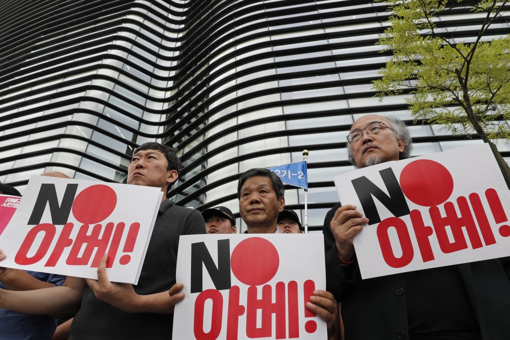 South Korean protesters hold signs during a rally denouncing the Japanese Prime Minister Shinzo Abe in front of the Japanese embassy in Seoul. Photo: AP